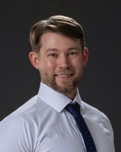 Dr. Allen Johnson wearing a button up and tie.